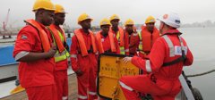 Eight men attending tool box talk onboard ship